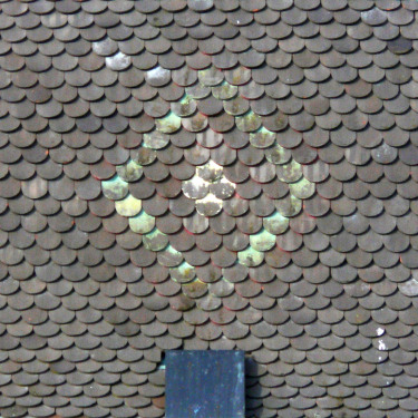 Détail du motif de tuiles du clocher de Navenne, photo Y. Bessero