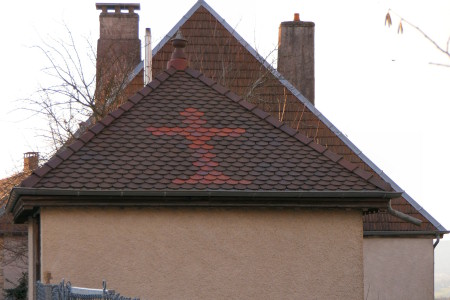 Motif de tuiles colorées sur un abri dans la cour de l'église de Saint-Hilaire, photo Y. Bessero
